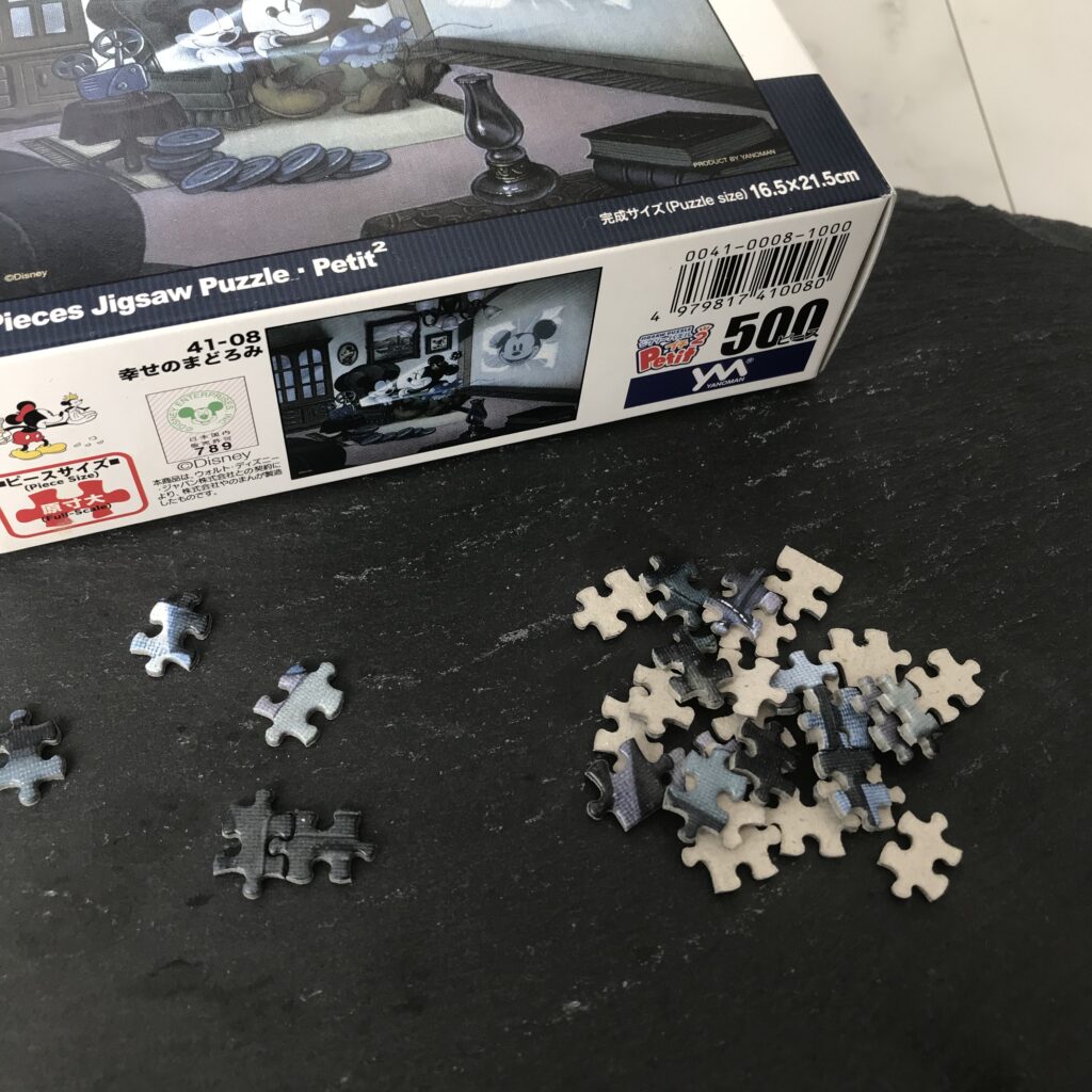 わたしが持っているスモールサイズのジクソーパズルのピースと箱の写真。