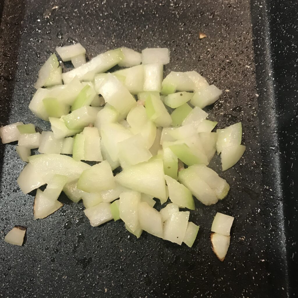 フライパンに玉ねぎを入れた写真。