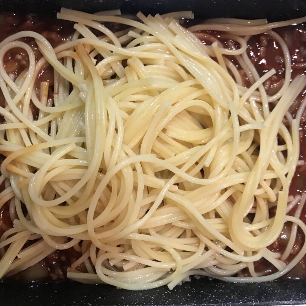 出来上がったミートソースにパスタ麺を入れた写真。